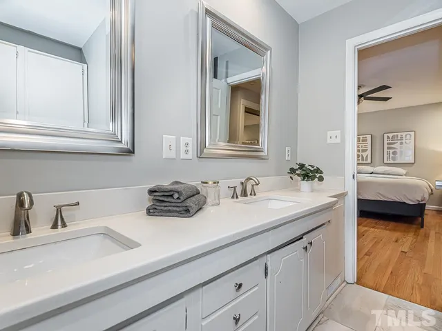 a bathroom with a granite countertop sink a toilet and a window
