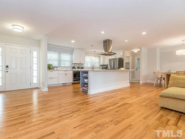 a view of kitchen with kitchen island sink refrigerator and white cabinets