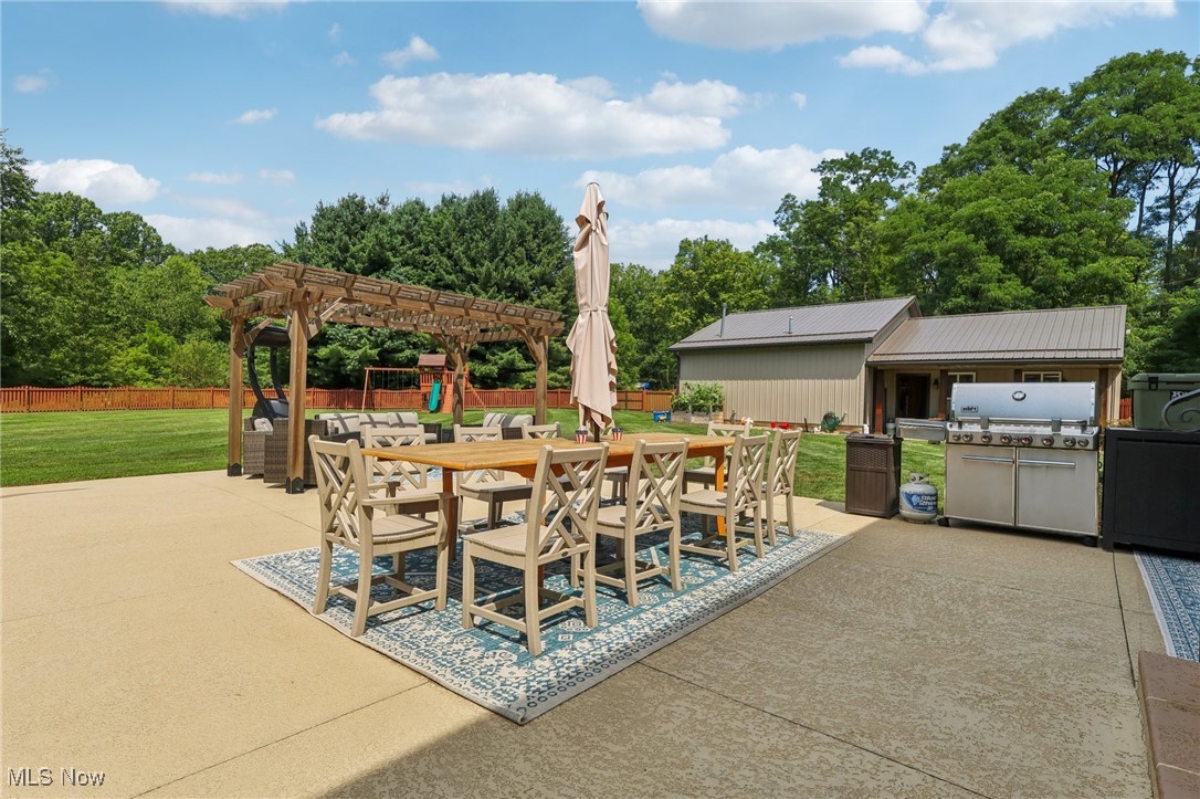 230 South Medina Line Road Akron, OH 44321 - Photo 41 of 50 View of patio featuring a pergola, outdoor dining space, an outdoor kitchen, and view of wooded area