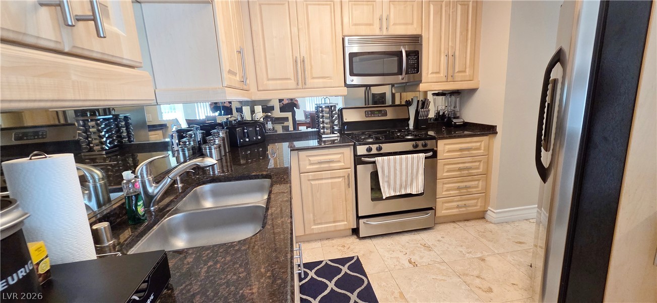 210 East Flamingo Road, Unit 208 Las Vegas, NV 89169 - Photo 16 of 42 Culinary adventures await in this functional kitchen, boasting durable stone countertops and sleek appliances.