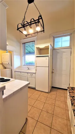 a kitchen with granite countertop a stove a sink and a refrigerator