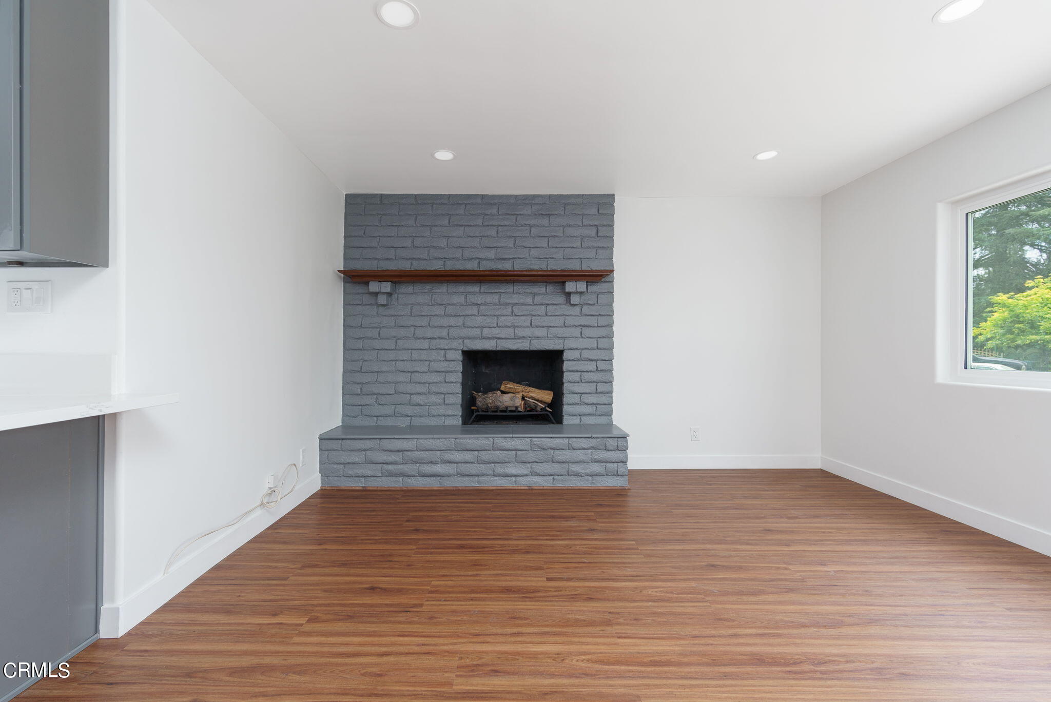 20205 Schoolcraft Street Winnetka, CA 91306 - Photo 11 of 22 a room with a fireplace and wooden floor