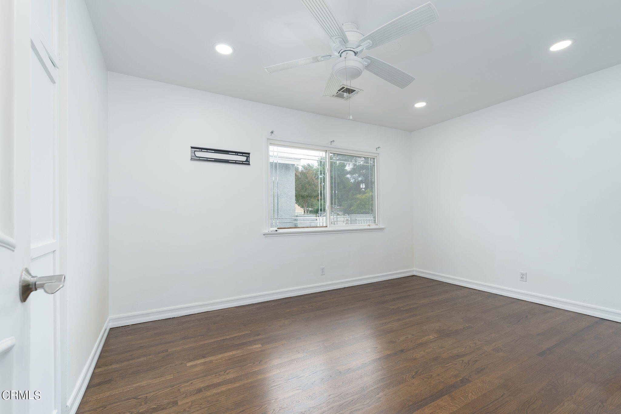 20205 Schoolcraft Street Winnetka, CA 91306 - Photo 16 of 22 an empty room with wooden floor and windows