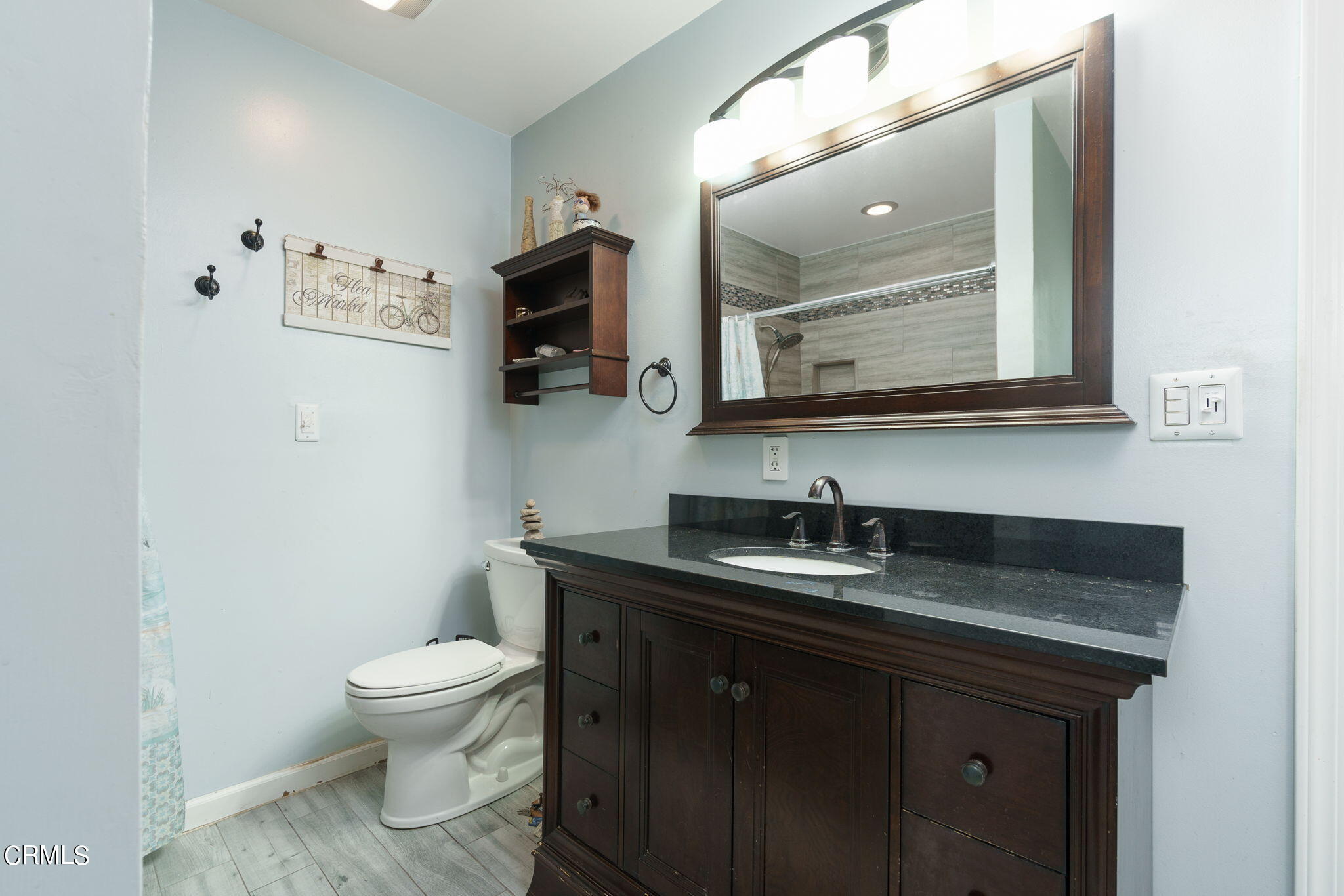 20205 Schoolcraft Street Winnetka, CA 91306 - Photo 20 of 22 a bathroom with a granite countertop toilet sink and mirror
