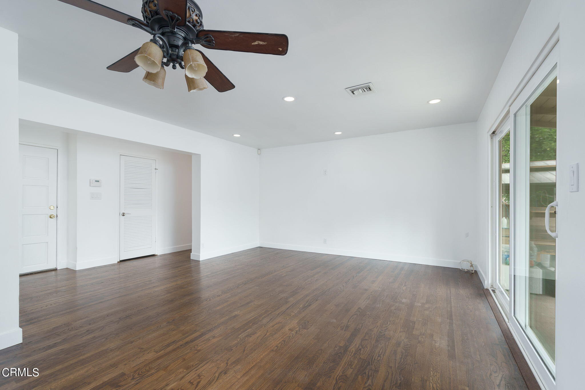20205 Schoolcraft Street Winnetka, CA 91306 - Photo 4 of 22 an empty room with wooden floor fan and windows
