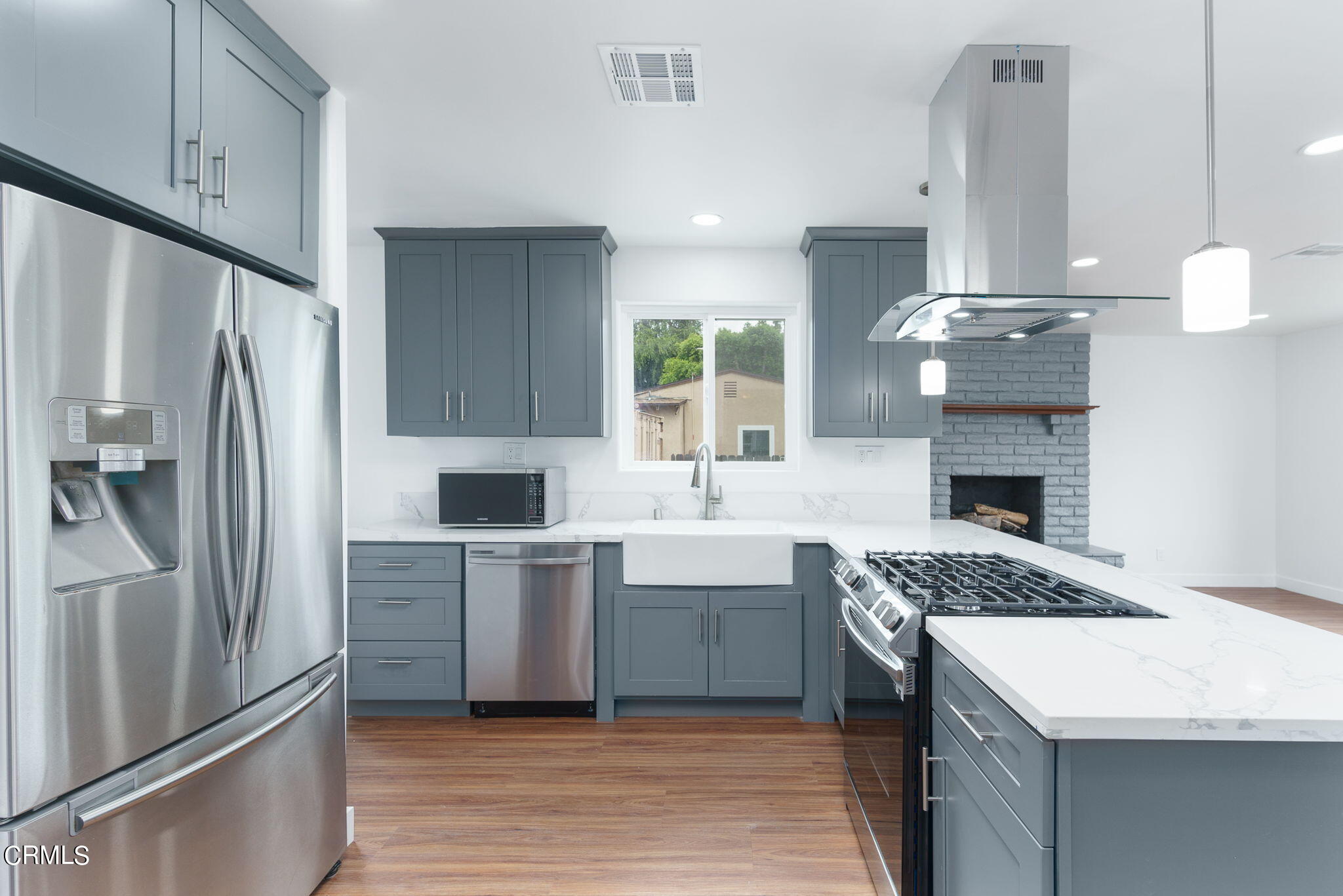 20205 Schoolcraft Street Winnetka, CA 91306 - Photo 9 of 22 a kitchen with kitchen island a counter top space a sink stainless steel appliances and cabinets