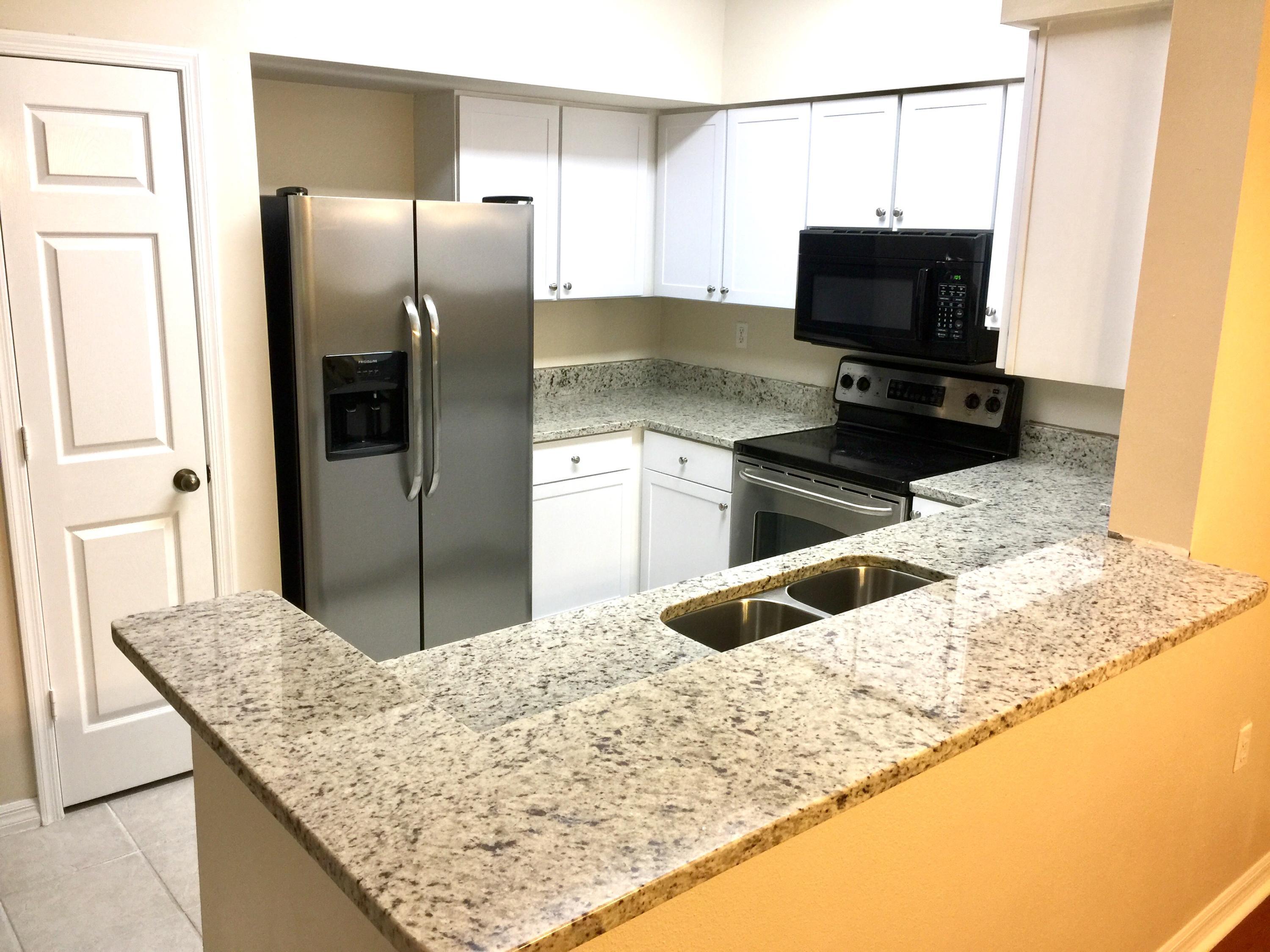 10000 Southwest 52nd Avenue, Unit 76 Gainesville, FL 32608 - Photo 2 of 21 a kitchen with granite countertop a sink stainless steel appliances and a counter top