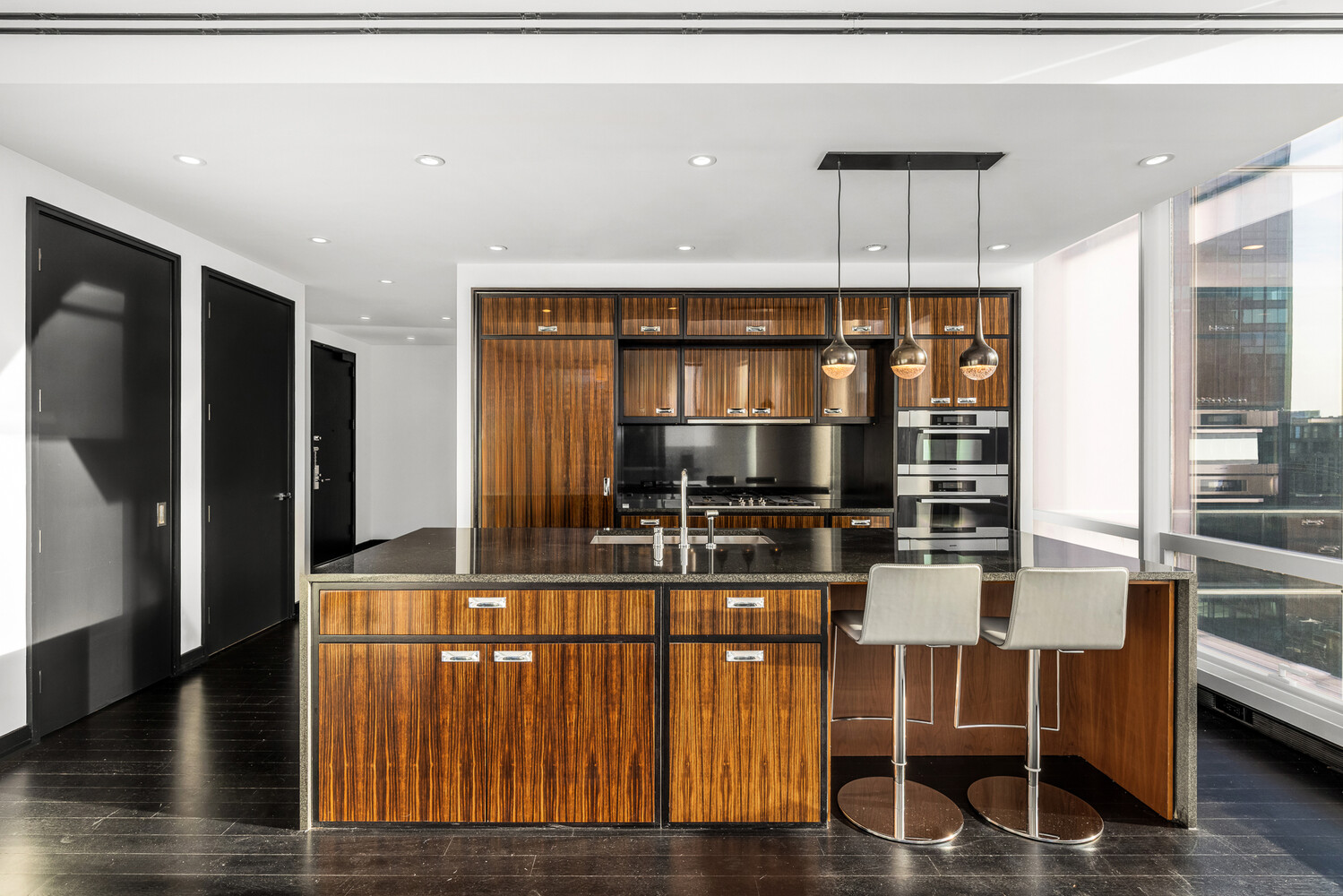 157 West 57th Street, Unit 43B Manhattan, NY 10019 - Photo 4 of 10 a kitchen with a table chairs refrigerator and cabinets