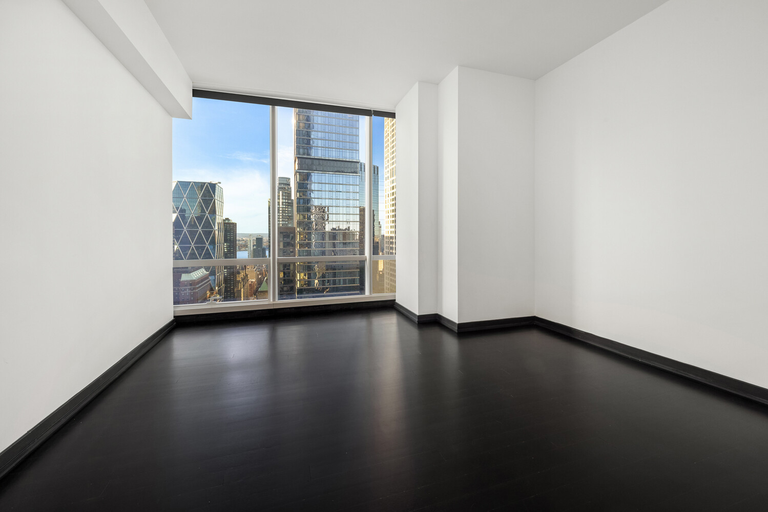 157 West 57th Street, Unit 43B Manhattan, NY 10019 - Photo 7 of 10 a view of room with window and wooden floor