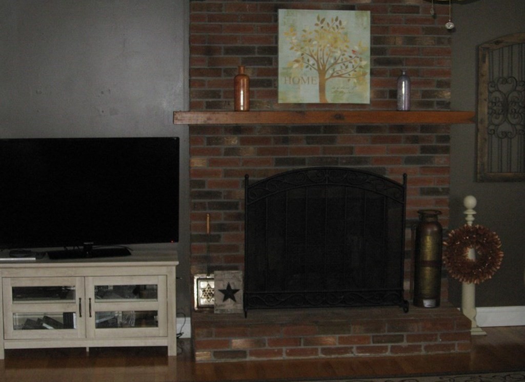 95 Grandview Street Springfield, MA 01118 - Photo 6 of 30 a living room with a fireplace and a flat screen tv