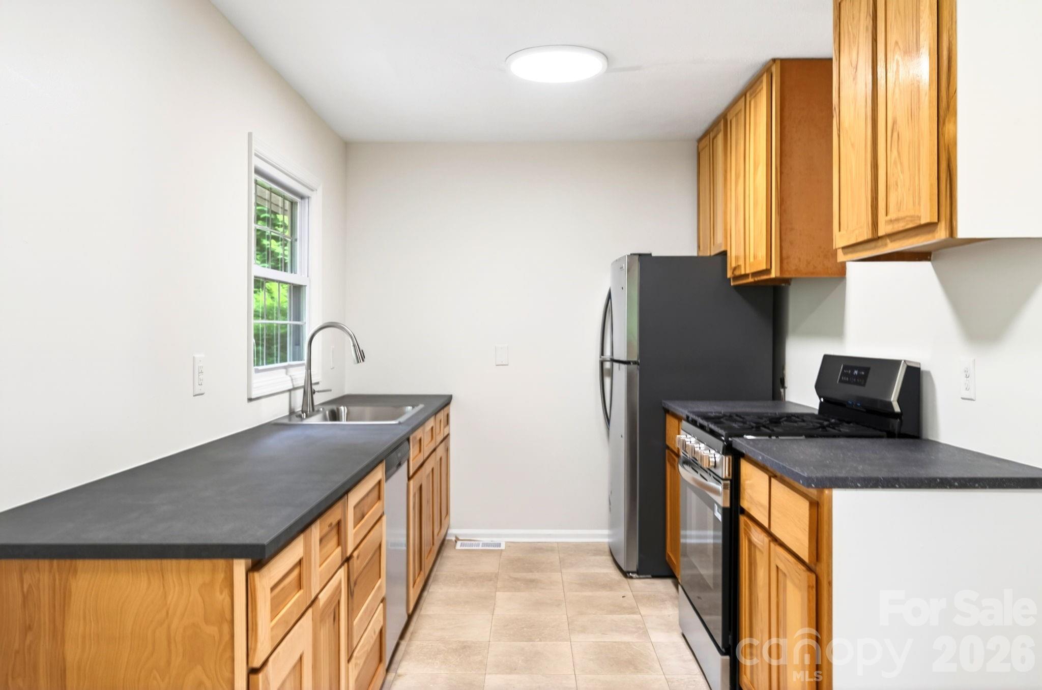 34 Wolfe Cove Road Asheville, NC 28804 - Photo 23 of 42 a kitchen with stainless steel appliances granite countertop a sink a stove and a refrigerator