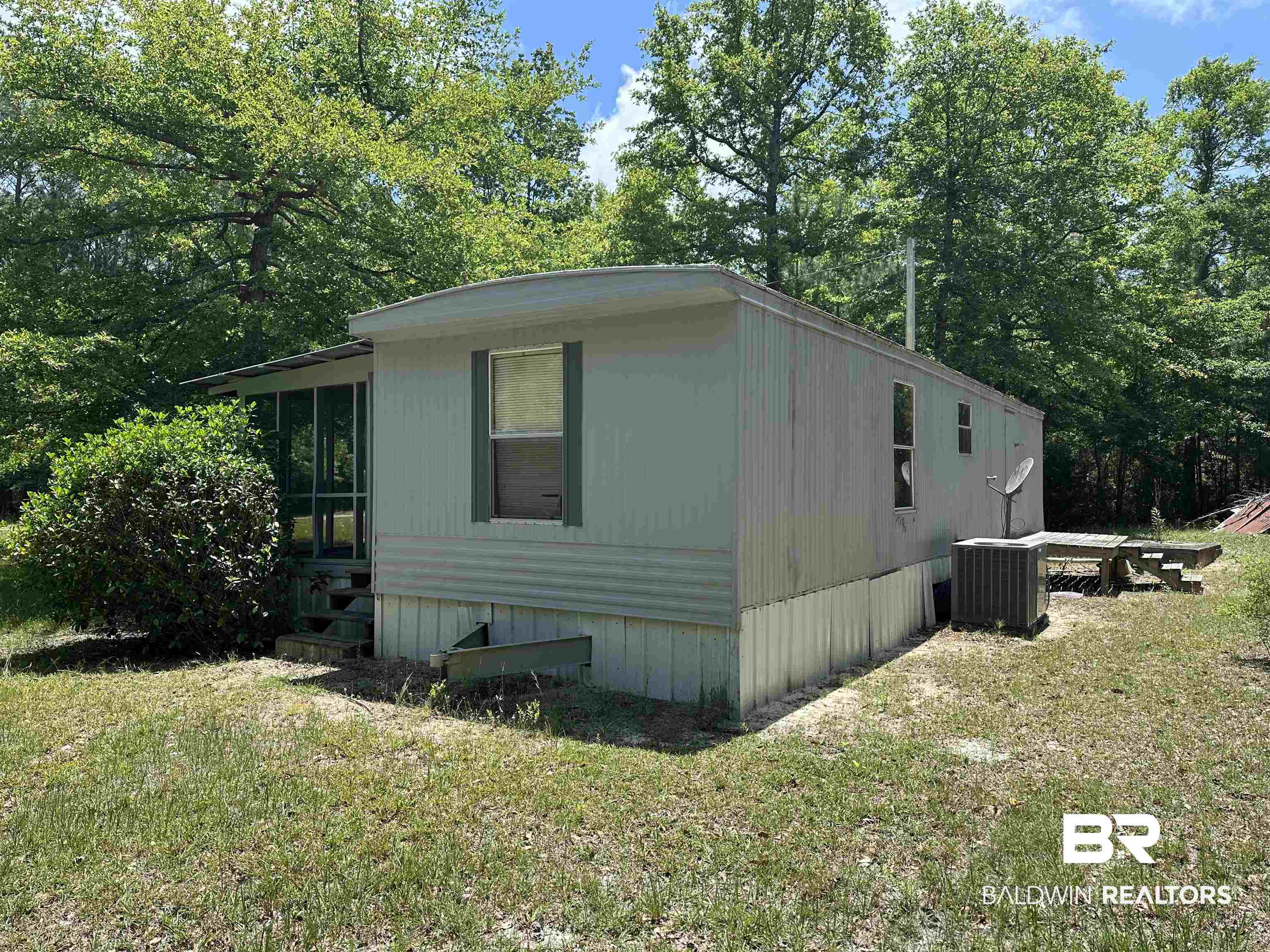 15660 Kennedy Road Bon Secour, AL 36511 - Photo 6 of 9 View of home's exterior with a lawn and central air condition unit