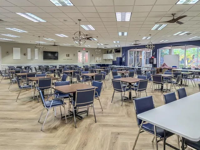 a front view of a building with garden and trees