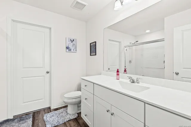 a bathroom with a sink a toilet and shower