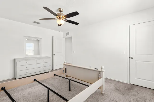an empty room with ceiling fan and window
