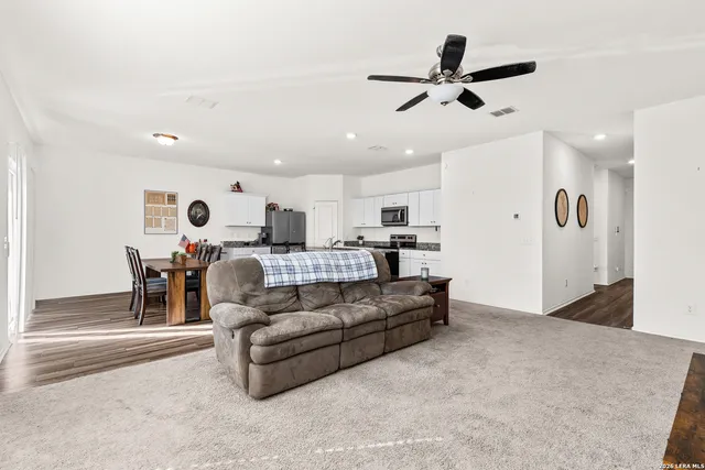 a living room with furniture and kitchen view