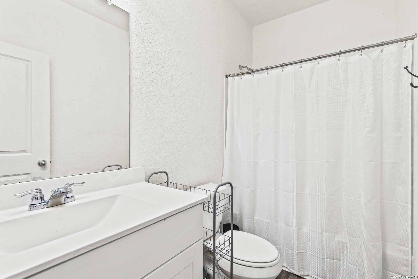 5802 Rue Picasso Converse, TX 78109 - Photo 7 of 23 a bathroom with a sink a toilet and shower curtain