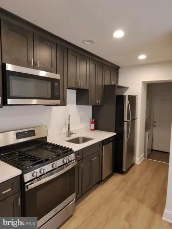 a kitchen with wooden cabinets and stainless steel appliances