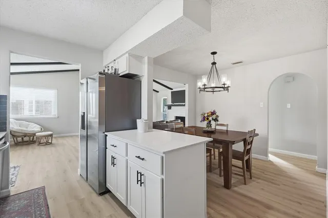 a kitchen with a sink refrigerator and wooden floor