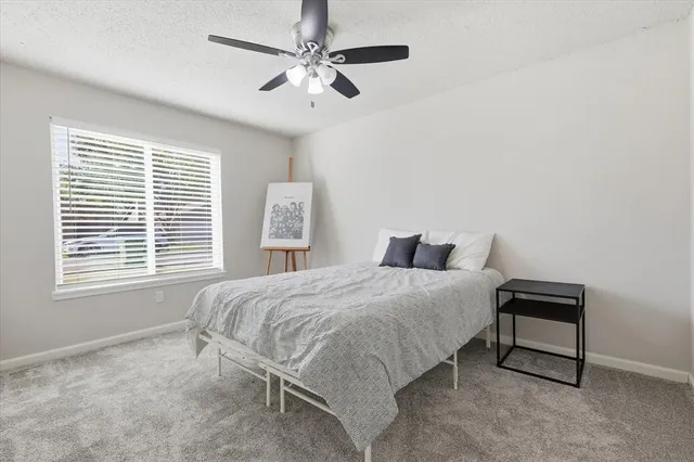 a bedroom with a bed a chandelier and a window