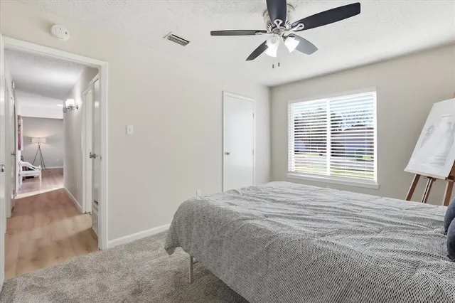 a bedroom with a bed and a walk in closet and wooden floor