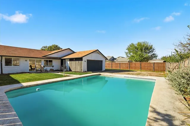 a view of a house with pool and a yard
