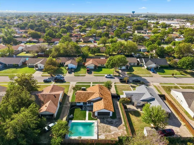 an aerial view of residential houses with outdoor space and swimming pool