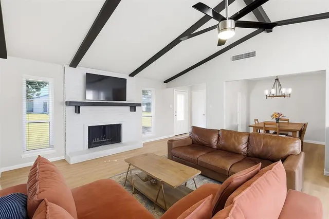 a living room with furniture a flat screen tv and a fireplace