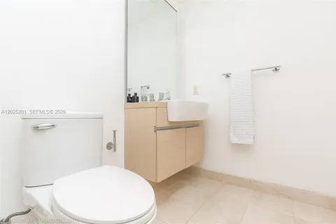 a white toilet next to a bathroom