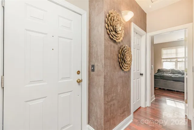 a hallway with painting on the wall and a large mirror