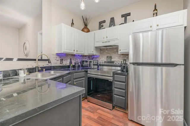 a kitchen with granite countertop a sink appliances and cabinets