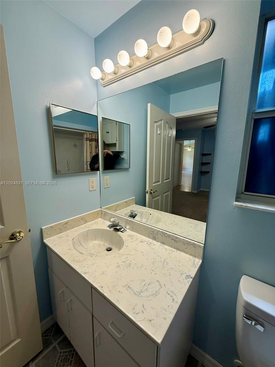 15819 76th Road North Loxahatchee, FL 33470 - Photo 38 of 45 a bathroom with a sink a toilet and a mirror