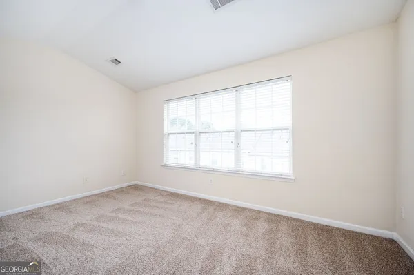 an empty room with windows and closet