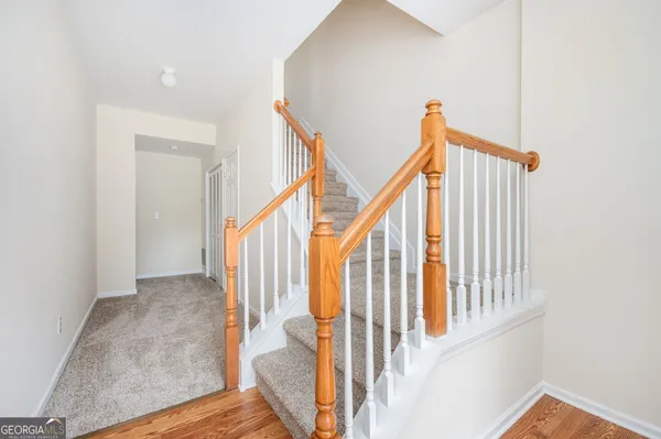 a view of staircase with railing and a chandelier