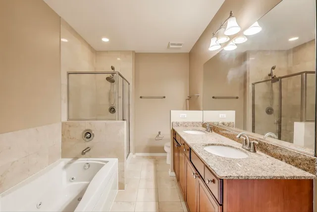 a bathroom with a granite countertop double vanity sink and mirror with shower