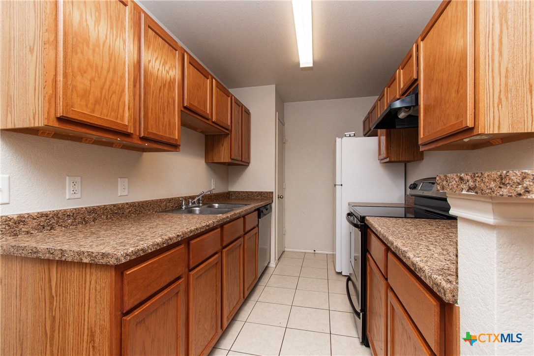 6509 Temora Loop, Unit A Killeen, TX 76549 - Photo 7 of 19 a kitchen with stainless steel appliances granite countertop a stove a sink and a microwave