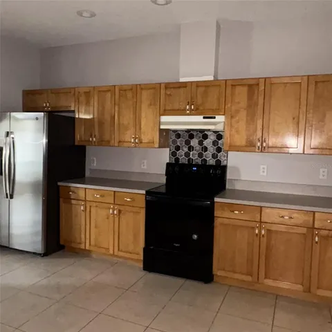 a kitchen with granite countertop a refrigerator and a stove