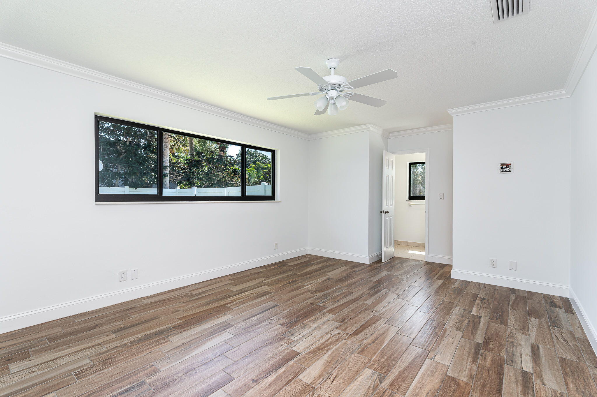 1151 Northwest 6th Avenue Boca Raton, FL 33432 - Photo 12 of 42 a view of empty room with wooden floor and fan