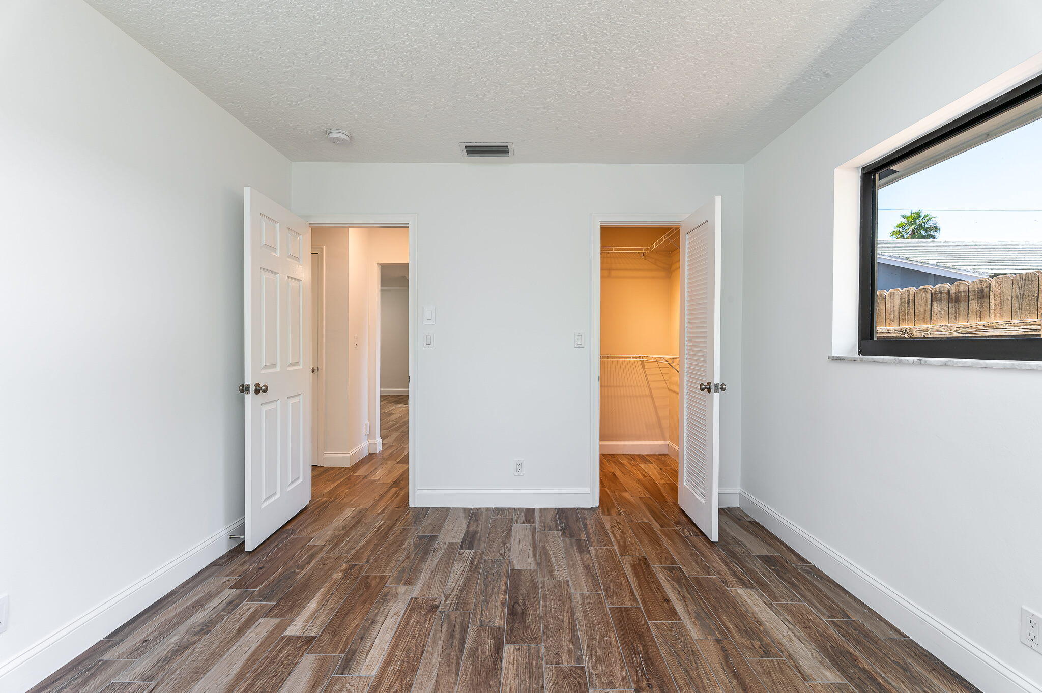 1151 Northwest 6th Avenue Boca Raton, FL 33432 - Photo 18 of 42 an empty room with wooden floor and a window