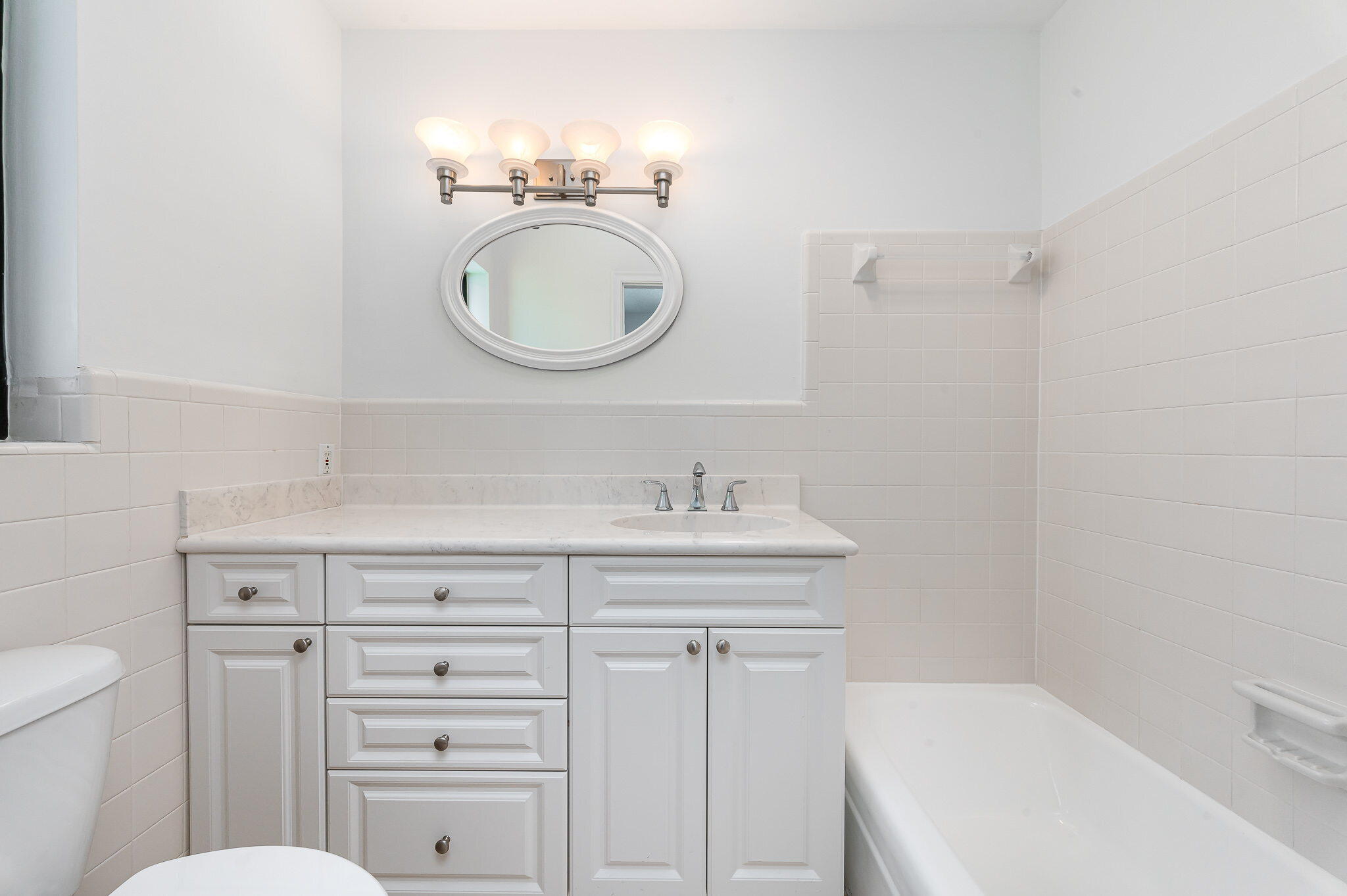 1151 Northwest 6th Avenue Boca Raton, FL 33432 - Photo 19 of 42 a bathroom with a toilet a sink a mirror and a bathtub