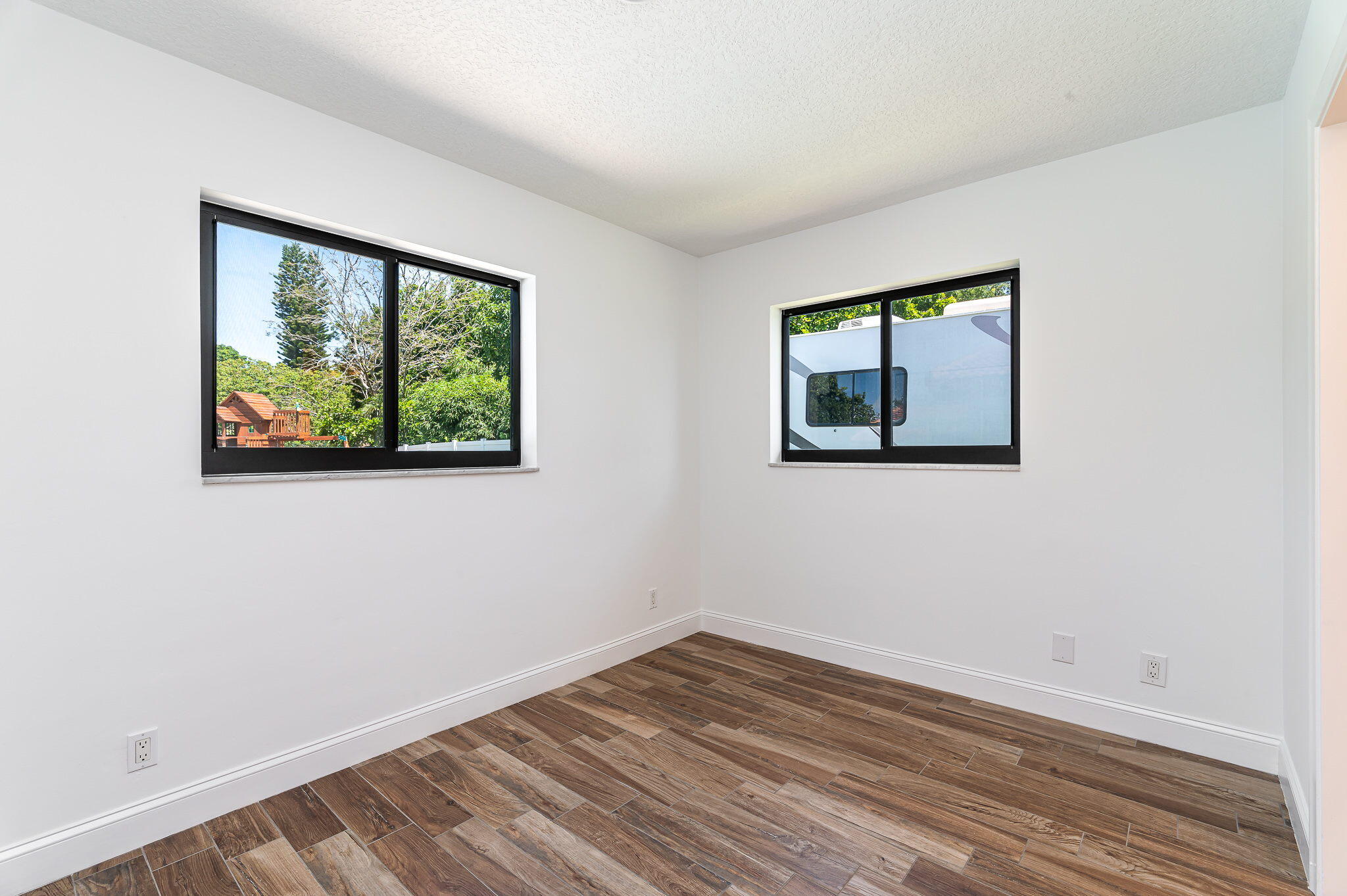 1151 Northwest 6th Avenue Boca Raton, FL 33432 - Photo 20 of 42 a view of empty room with wooden floor and fan