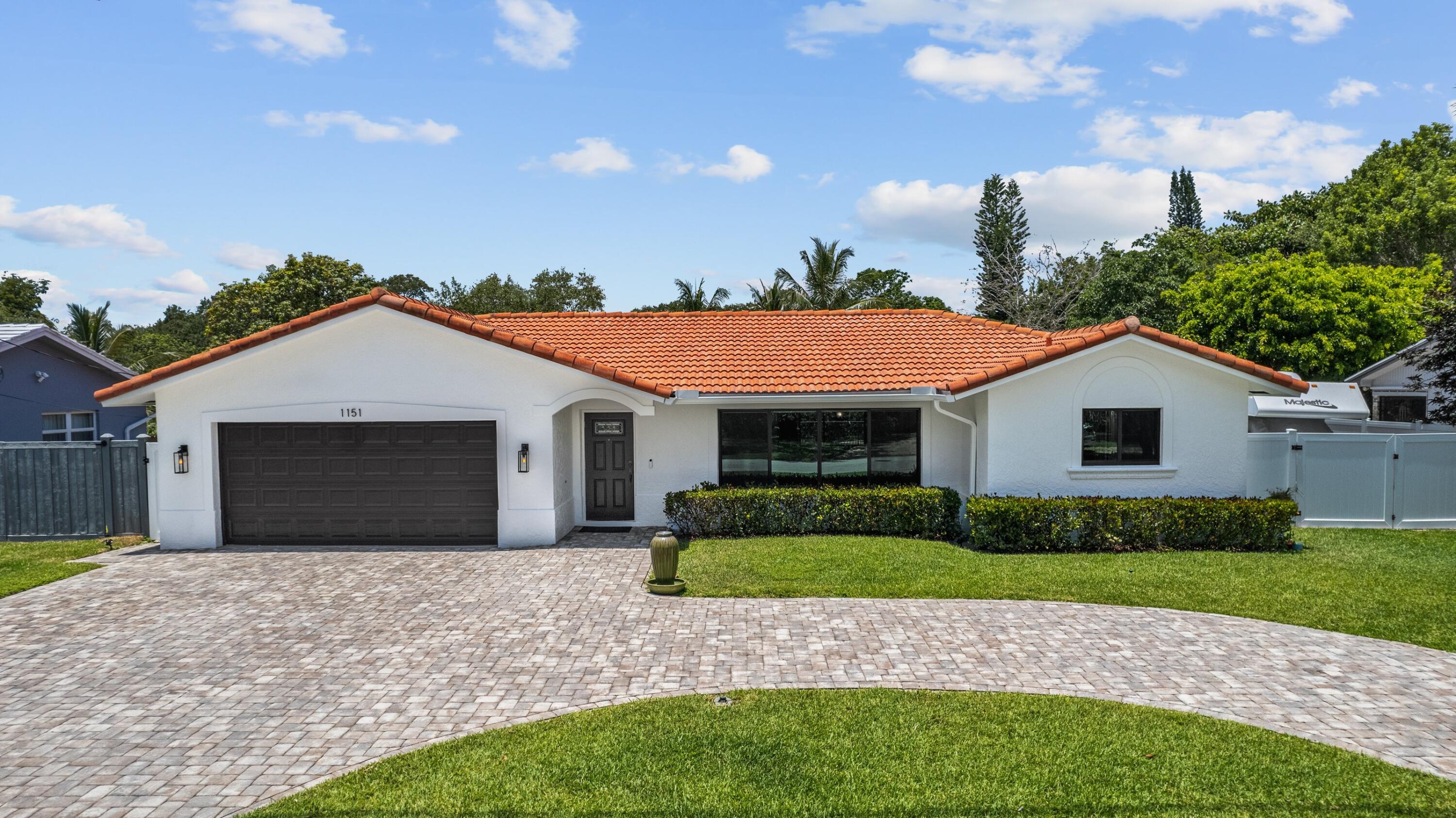 1151 Northwest 6th Avenue Boca Raton, FL 33432 - Photo 2 of 42 a front view of a house with a garden and yard