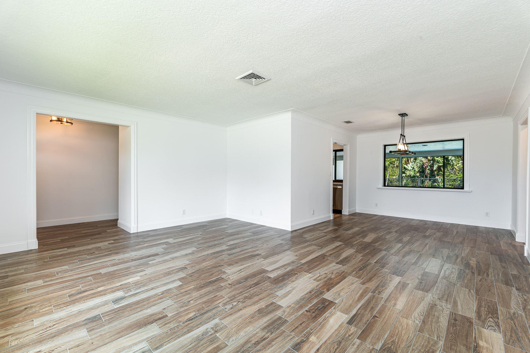 1151 Northwest 6th Avenue Boca Raton, FL 33432 - Photo 5 of 42 a view of an empty room with wooden floor and a window