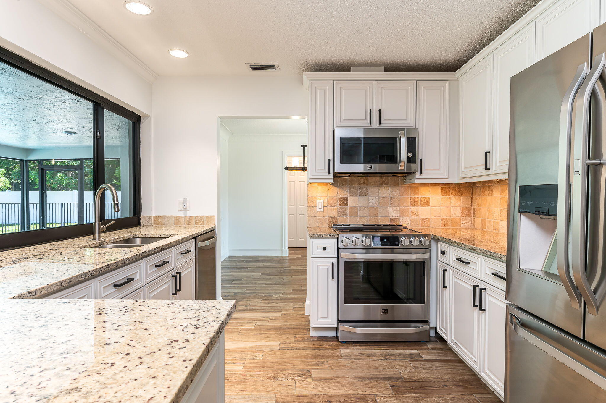1151 Northwest 6th Avenue Boca Raton, FL 33432 - Photo 8 of 42 a kitchen with stainless steel appliances granite countertop a stove a sink and a refrigerator