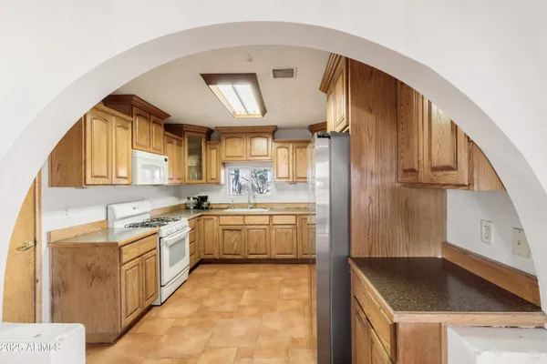 a kitchen with granite countertop a sink stainless steel appliances and cabinets