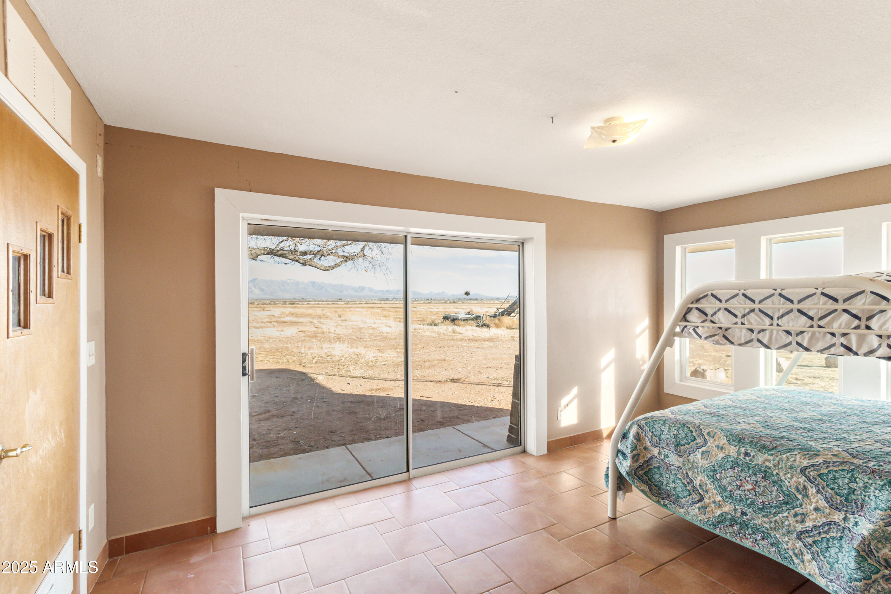 4842 West Gleeson Road Elfrida, AZ 85610 - Photo 27 of 51 a bedroom with a bed and glass door