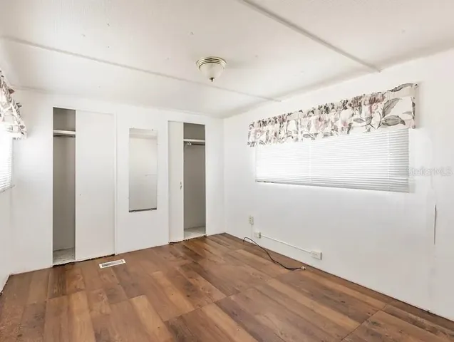 a view of empty room with wooden floor