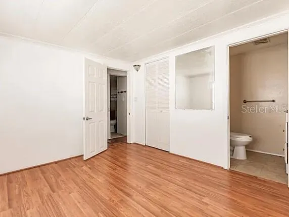 a view of a room with wooden floor and toilet