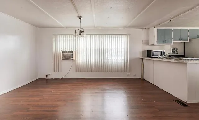 a view of a kitchen with wooden floor a sink and dishwasher