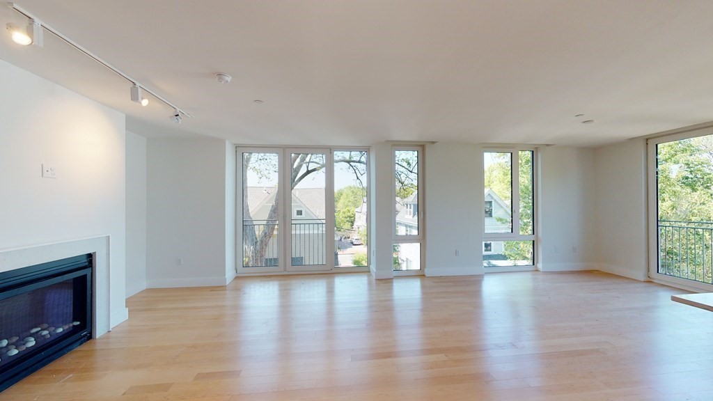 7 Beech Street, Unit 211 Cambridge, MA 02140 - Photo 2 of 7 a view of an empty room with a window and wooden floor